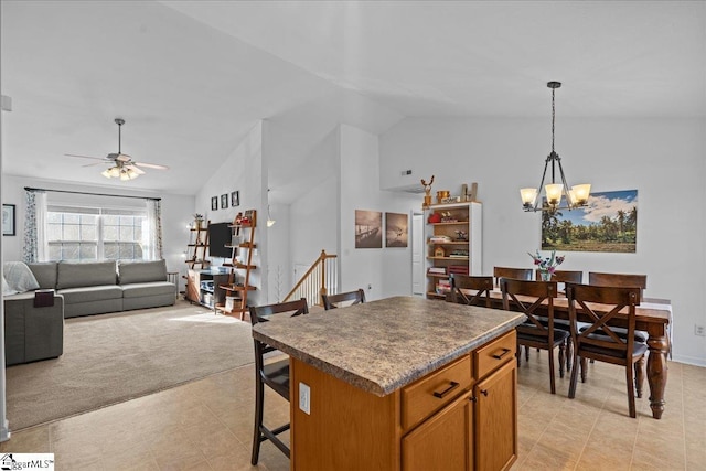 kitchen with a center island, hanging light fixtures, vaulted ceiling, a kitchen bar, and ceiling fan with notable chandelier