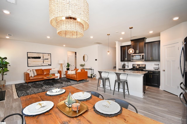 dining room with a chandelier, light hardwood / wood-style floors, and sink