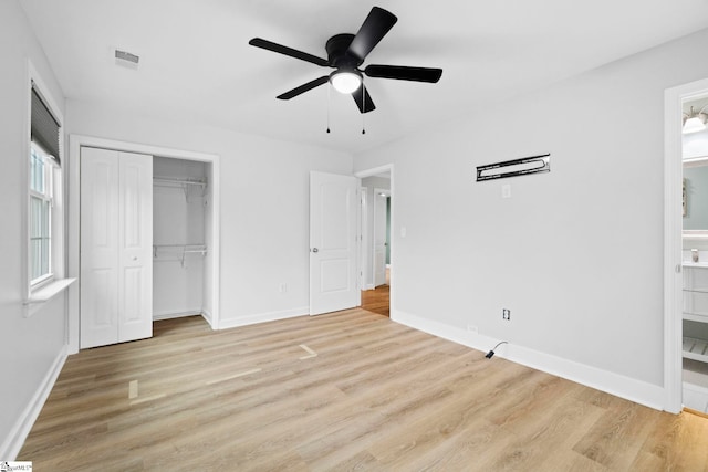 unfurnished bedroom featuring a closet, light hardwood / wood-style flooring, ceiling fan, and ensuite bathroom