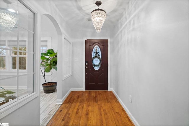 doorway to outside featuring a chandelier and hardwood / wood-style flooring