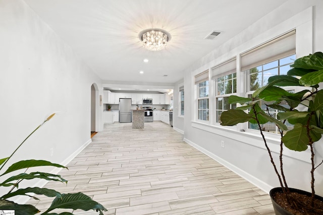 hallway featuring a notable chandelier