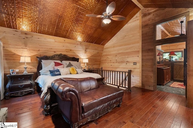 bedroom featuring vaulted ceiling, ceiling fan, wood walls, and dark hardwood / wood-style floors