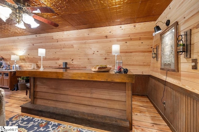 bar with wood walls, ceiling fan, light hardwood / wood-style floors, and butcher block counters