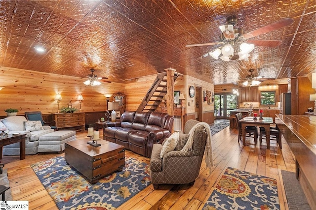 living room featuring light wood-type flooring and wood walls