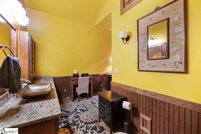 interior space featuring sink, lofted ceiling, and wood walls