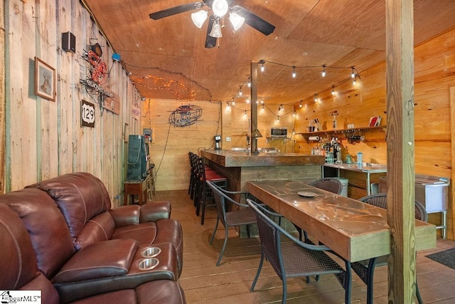 bar with ceiling fan, wood walls, wood-type flooring, and wood ceiling