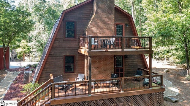 back of house featuring central AC unit and a wooden deck