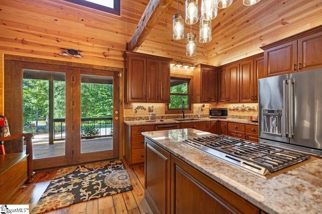 kitchen with pendant lighting, hardwood / wood-style floors, light stone countertops, appliances with stainless steel finishes, and wood ceiling