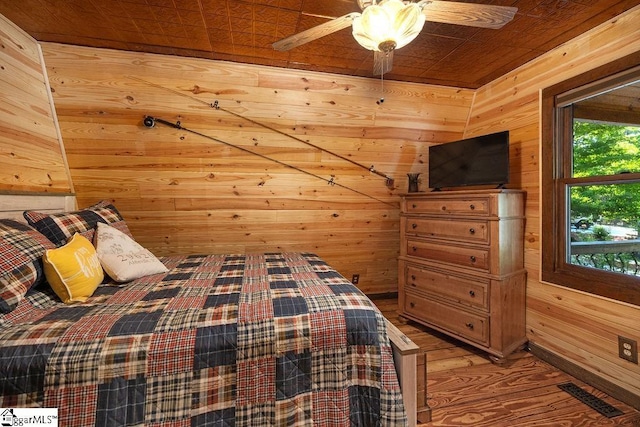 unfurnished bedroom featuring ceiling fan, hardwood / wood-style floors, wooden ceiling, and wood walls