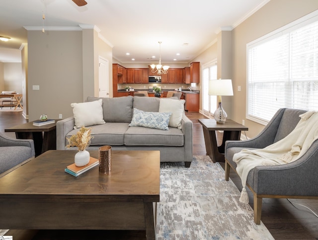 living room featuring ceiling fan with notable chandelier, light hardwood / wood-style floors, and ornamental molding