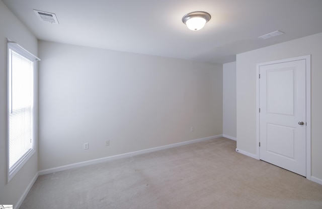 unfurnished room featuring light carpet