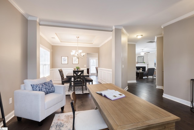 office space featuring ceiling fan with notable chandelier, dark hardwood / wood-style floors, a tray ceiling, and ornamental molding