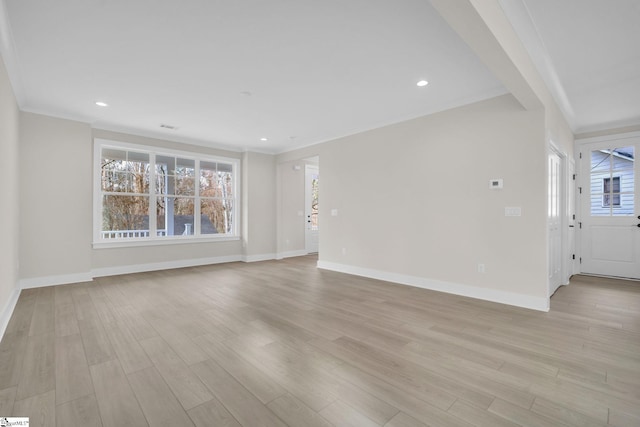 spare room with light hardwood / wood-style flooring and crown molding