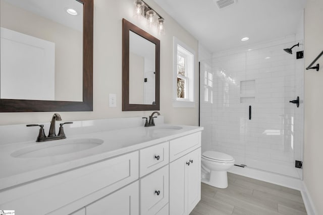 bathroom featuring vanity, an enclosed shower, and toilet