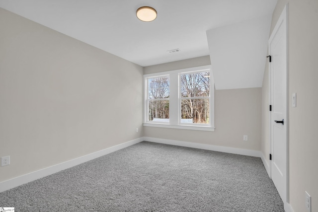 unfurnished room featuring carpet flooring and vaulted ceiling