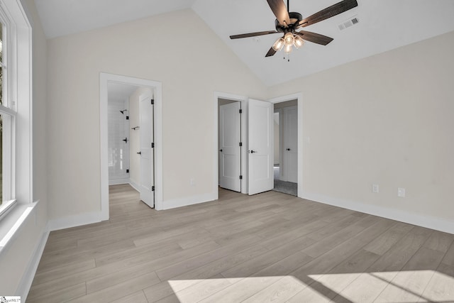 unfurnished bedroom featuring ceiling fan, light wood-type flooring, ensuite bathroom, and high vaulted ceiling