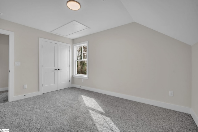 unfurnished bedroom featuring a closet, carpet, and vaulted ceiling