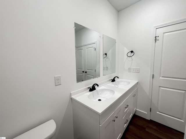 bathroom with vanity, wood-type flooring, and toilet