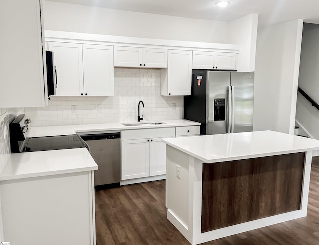 kitchen featuring stainless steel appliances, a kitchen island, white cabinetry, and sink