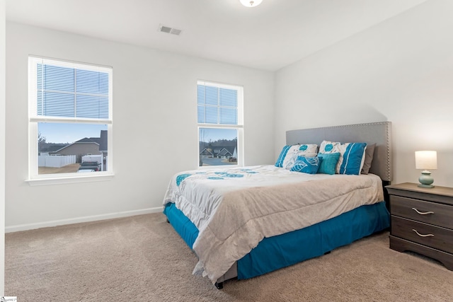 carpeted bedroom featuring multiple windows