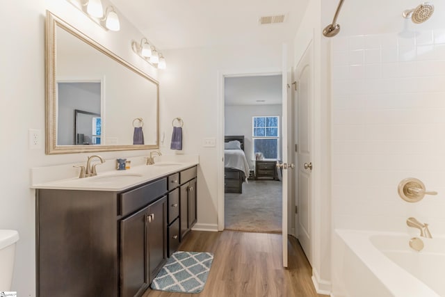 full bathroom featuring vanity, toilet, wood-type flooring, and shower / tub combination