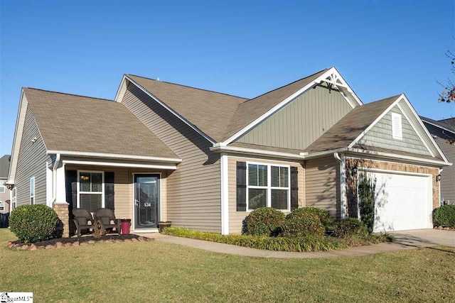 view of front of property with a porch, a front yard, and a garage