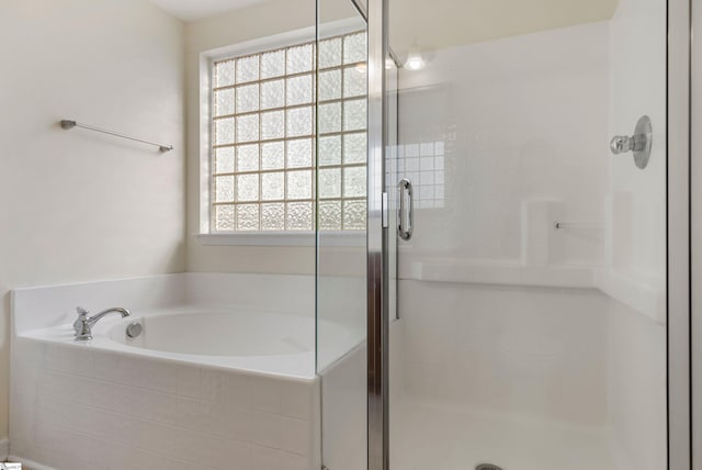 bathroom featuring independent shower and bath