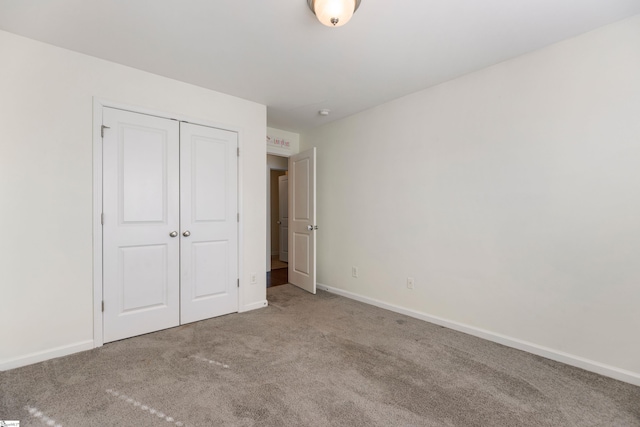 unfurnished bedroom featuring carpet flooring and a closet