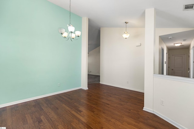 empty room with a chandelier, vaulted ceiling, and dark wood-type flooring