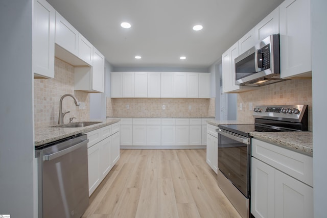 kitchen featuring white cabinets, light hardwood / wood-style floors, sink, and stainless steel appliances