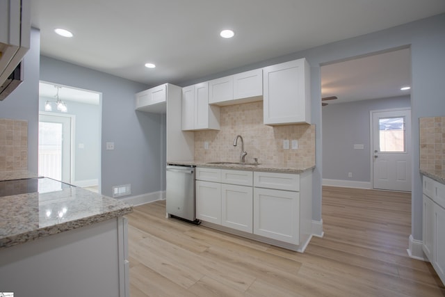 kitchen featuring white cabinets, tasteful backsplash, light hardwood / wood-style flooring, and light stone countertops