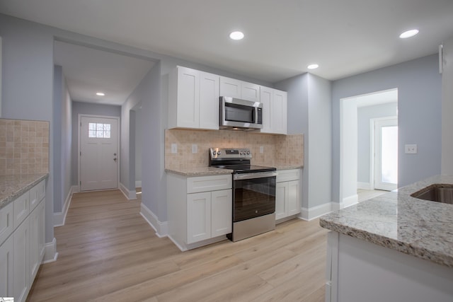 kitchen featuring light stone countertops, white cabinetry, and appliances with stainless steel finishes