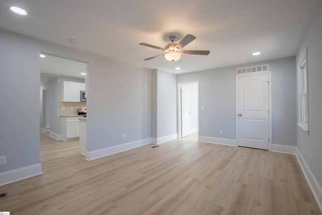 spare room featuring light wood-type flooring and ceiling fan