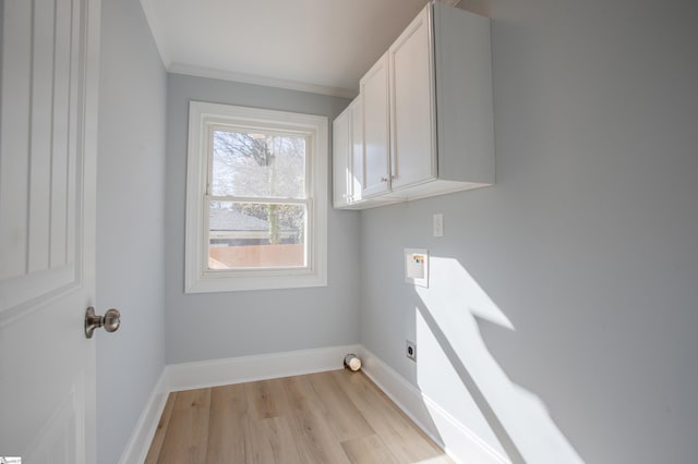 washroom featuring cabinets, hookup for a washing machine, ornamental molding, electric dryer hookup, and light hardwood / wood-style floors