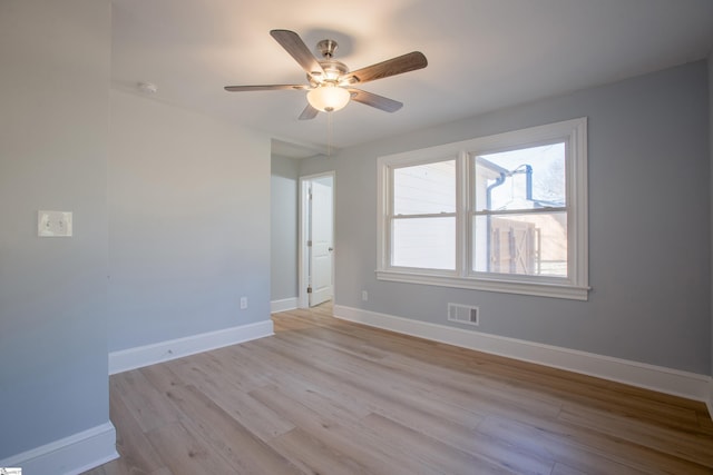 empty room with ceiling fan and light hardwood / wood-style floors