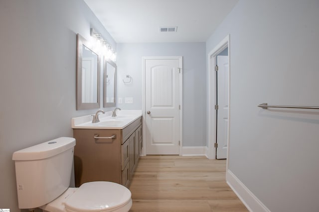 bathroom featuring vanity, toilet, and wood-type flooring