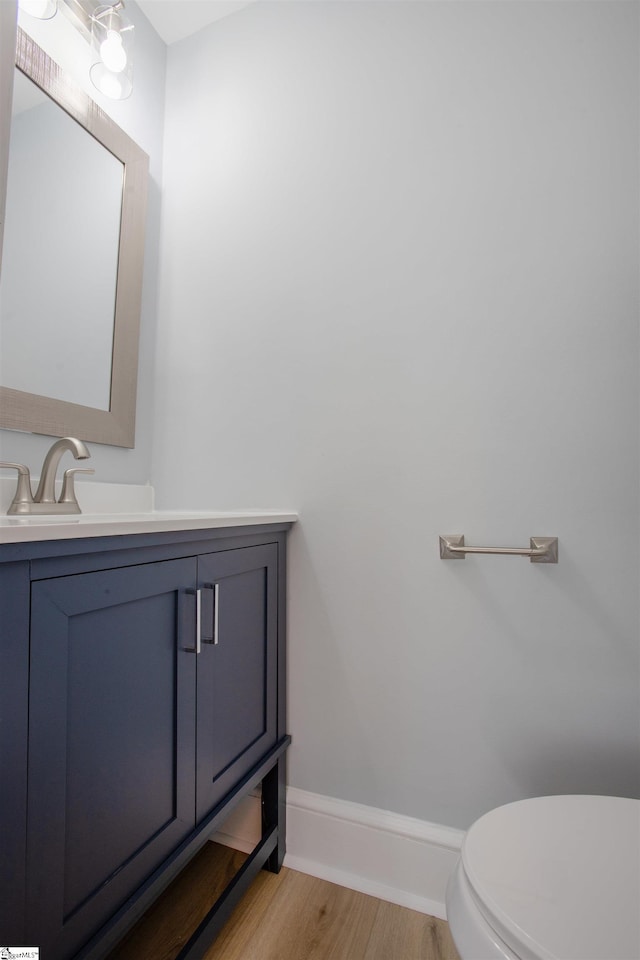 bathroom with vanity, hardwood / wood-style flooring, and toilet