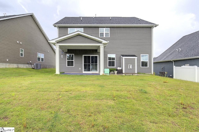 back of property with cooling unit and a lawn