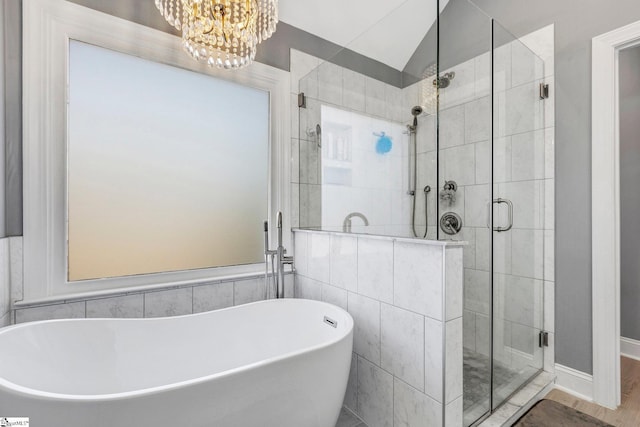 bathroom featuring wood-type flooring, lofted ceiling, shower with separate bathtub, and an inviting chandelier