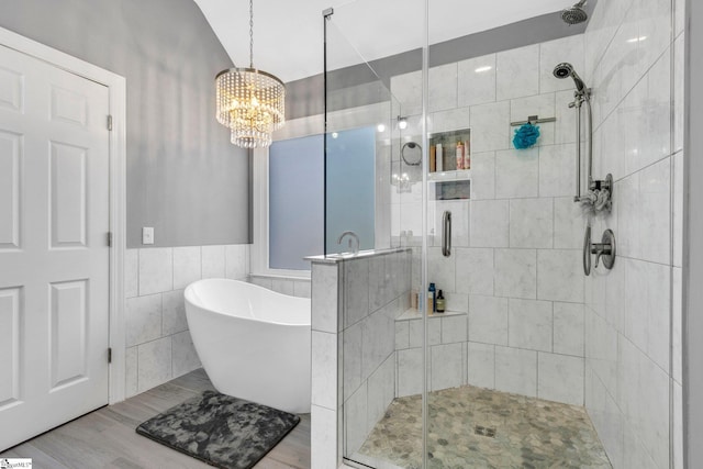 bathroom with a chandelier, lofted ceiling, shower with separate bathtub, tile walls, and hardwood / wood-style flooring