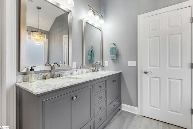 bathroom featuring hardwood / wood-style flooring, a notable chandelier, and vanity