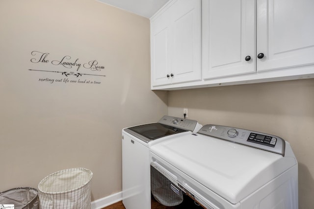 clothes washing area with cabinets and washing machine and dryer