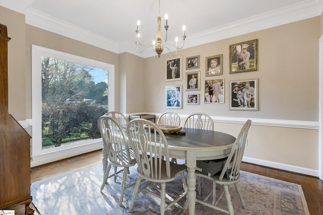 dining room with hardwood / wood-style flooring, crown molding, a wealth of natural light, and a notable chandelier