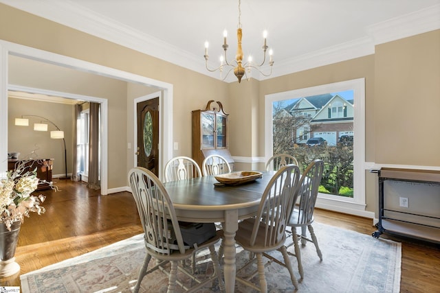 dining room with ornamental molding, dark wood-type flooring, and an inviting chandelier