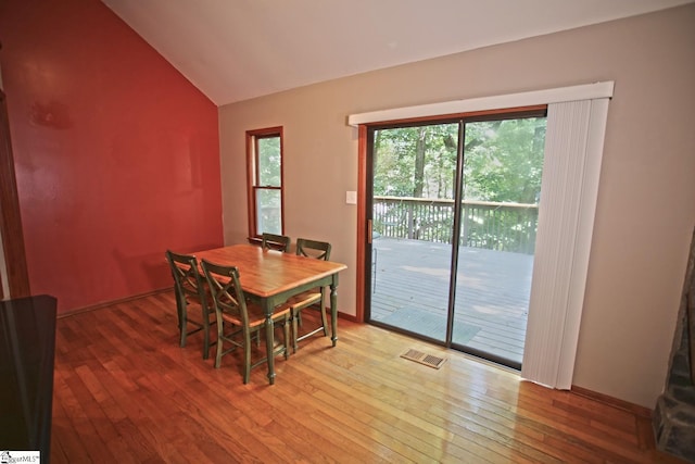 dining room featuring lofted ceiling and wood-type flooring