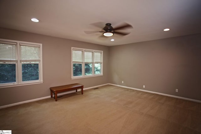 carpeted spare room featuring ceiling fan