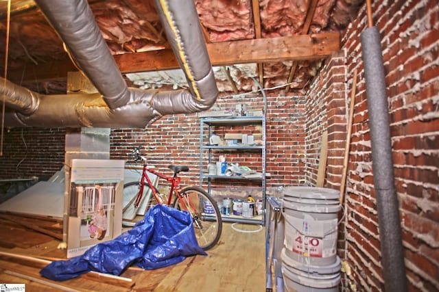 interior space with hardwood / wood-style floors and brick wall