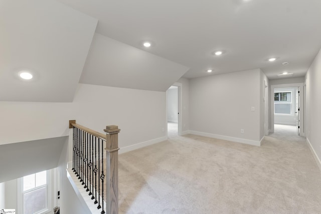 hallway featuring light colored carpet