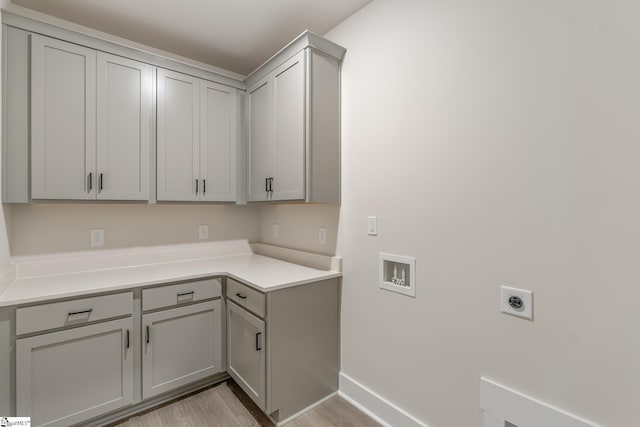 clothes washing area with light hardwood / wood-style flooring, hookup for a washing machine, hookup for an electric dryer, and cabinets