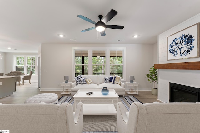 living room featuring light wood-type flooring and ceiling fan